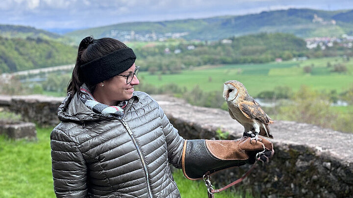Foto der Lehrerin mit einem Greifvogel auf dem Arm